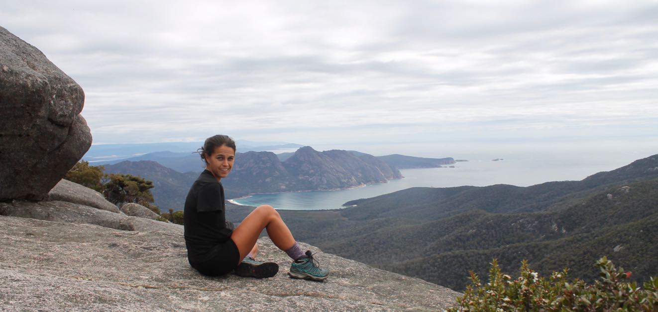 Kelli takes a break after hiking to the top of Mount Freycinet and enjoys the view back to Wine Glass Bay