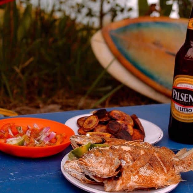 Fried whole fish with potatoes, a tomato cucumber salad and a beer