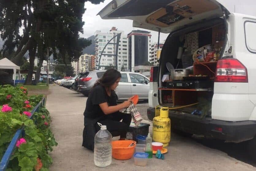 A woman washing dishes in a park in Quito Ecuador van life South America