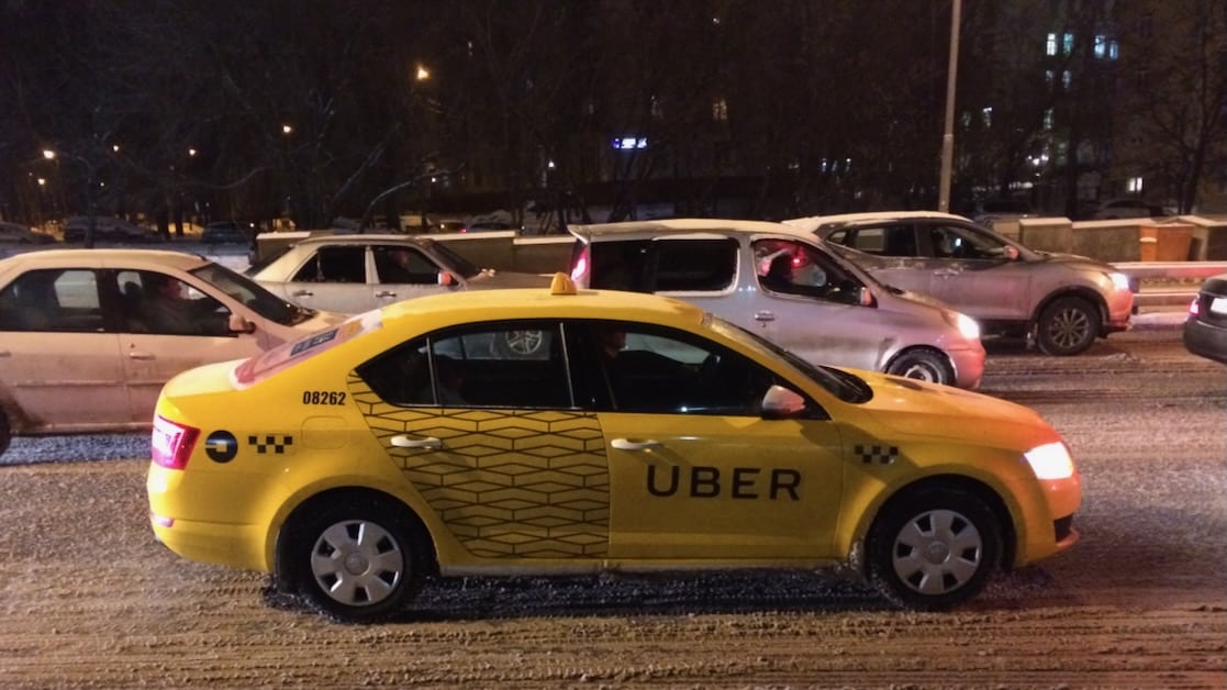 A yellow taxi with Uber branding
