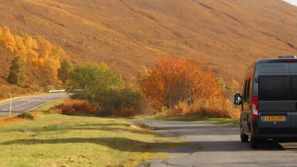Van parked on the side of the road with lovely fall colors.
